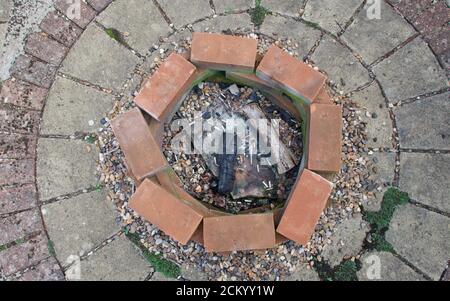 View of home made fire pit from above with ash charred wood and cigarette ends Stock Photo