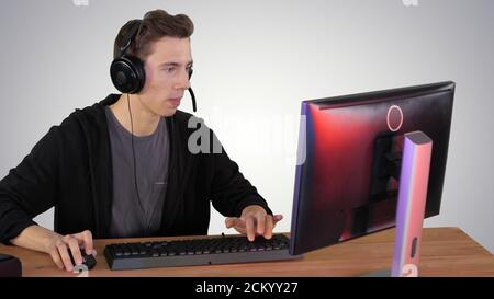 Gamer guy in headphones playing video games on computer and winn Stock Photo