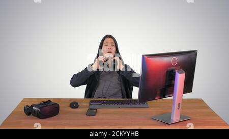 Stressed tired out of work hacker looking at pc monitor on gradi Stock Photo
