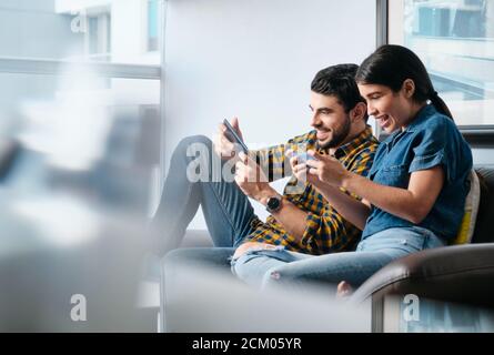 Happy People Playing Video Game With Smartphone And Laughing Stock Photo