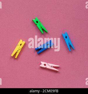 Bright multicolored wooden clothespins on a colored background, top view, flat lay Stock Photo