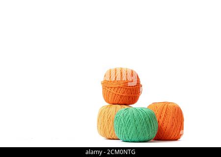 Colored balls of crochet thread on a white background . Copy space. The tangles are arranged in a column. Article about crocheting. Selection of threa Stock Photo
