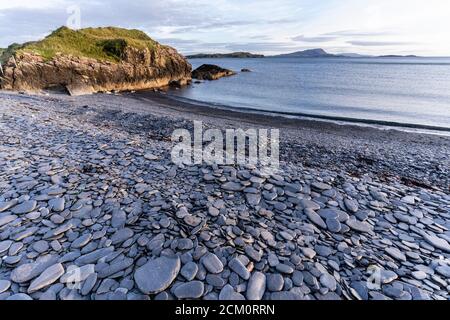 The unique slate beach of Ellenabeich on Seil Island, Argyll, Scotland where a former slate quarry created a breakwater and lagoon. Site of stone skim Stock Photo