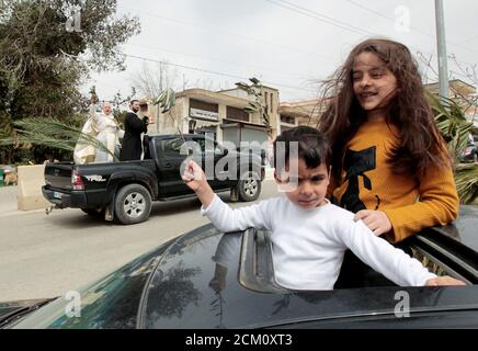 Children hold olive branches as they look out from the sunroof of a car to be blessed by priests roaming around neighbourhoods to celebrate Palm Sunday, amid the lockdown to contain the coronavirus disease (COVID-19), in Marjayoun, southern Lebanon  April 5, 2020. REUTERS/Aziz Taher     TPX IMAGES OF THE DAY