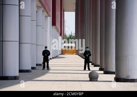 Security personnel stand guard outside a convention center that was used as a makeshift hospital to treat patients with the coronavirus disease (COVID-19), in Wuhan, Hubei province, China April 9, 2020.  REUTERS/Aly Song