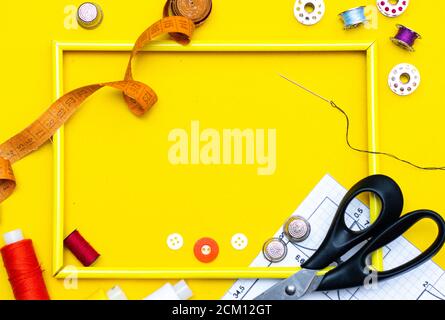 Layout sewing. needlework, craft, sewing and tailoring concept - box with thread spools and buttons on the table. The concept of sewing accessories. F Stock Photo