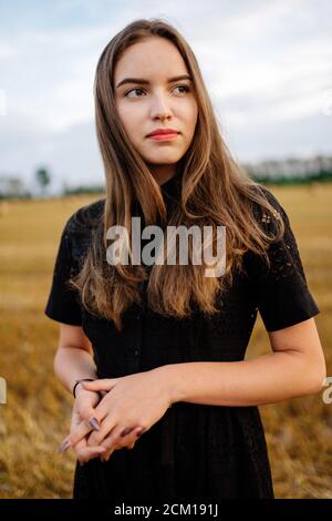 Woman in black dress outdoors in the field Stock Photo