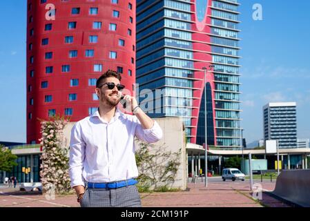 Portrait of Handsome young man smiling while using a mobile phone Stock Photo