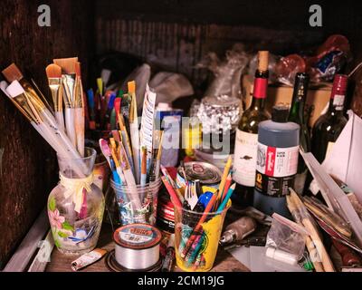Paintbrushes and other objects and clutter in an artists studio. Stock Photo