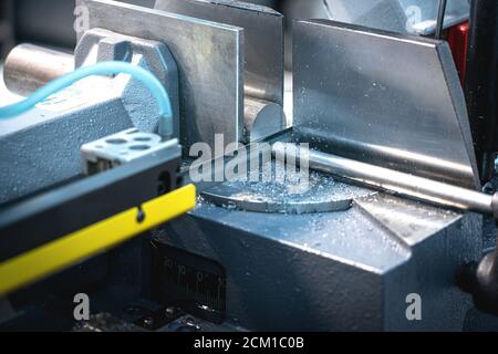 Industrial metal bar cutting process By CNC machinery with high precision electric saws and coolants. Stock Photo