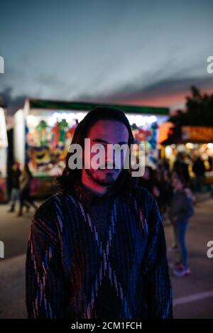Young man with long hair in a red and purple light posing Stock Photo
