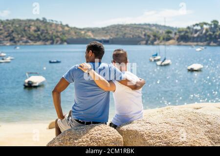 gay couple hugging by the sea Stock Photo