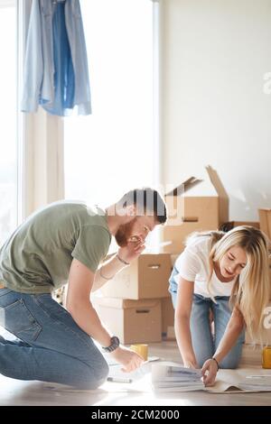 Portrait of happy caucsian couple planning new house design looking at paper Stock Photo