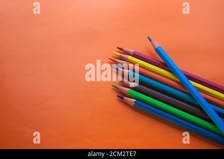 Colored pencils for drawing on an orange surface and with copy space Stock Photo