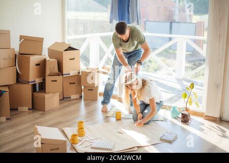 Portrait of happy caucsian couple planning new house design looking at paper Stock Photo