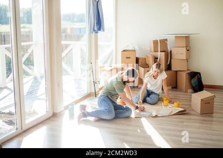 Portrait of happy caucsian couple planning new house design looking at paper Stock Photo