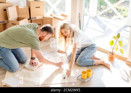 Portrait of happy caucsian couple planning new house design looking at paper Stock Photo