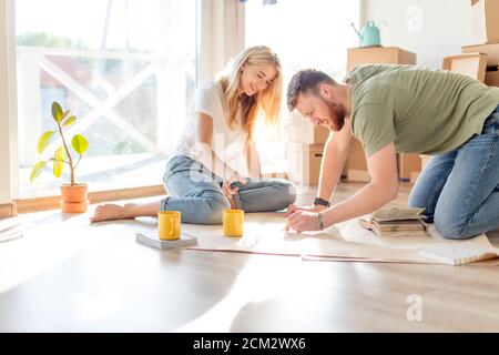 Portrait of happy caucsian couple planning new house design looking at paper Stock Photo