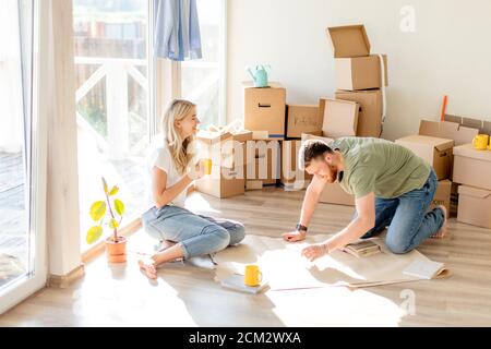 Portrait of happy caucsian couple planning new house design looking at paper Stock Photo