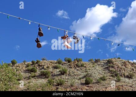 Sneakers dangling from a string of lights. Stock Photo