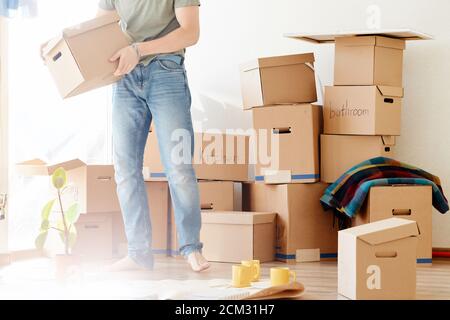 Smiling man hold boxes in new home. Dreaming new home Stock Photo