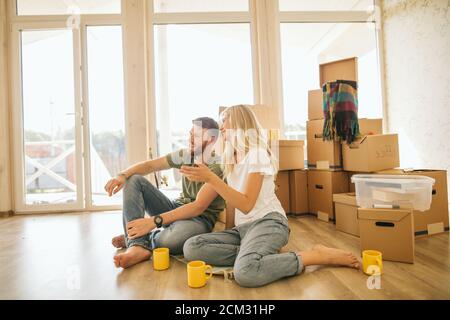 Couple Choosing wallpapper For New Home while sitting in bright room Stock Photo