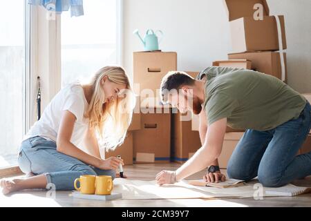 Portrait of happy caucsian couple planning new house design looking at paper Stock Photo