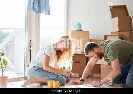 Portrait of happy caucsian couple planning new house design looking at paper Stock Photo