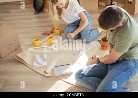 Portrait of happy caucsian couple planning new house design looking at paper Stock Photo