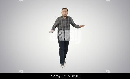 Young man in a casual outfit walking and dancing on gradient bac Stock Photo