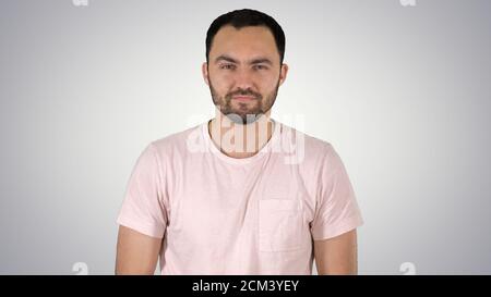 Young happy man in t-shirt smiling at camera and walking on grad Stock Photo