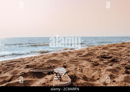 Summer beach at the sea with flip-flops on sand Stock Photo