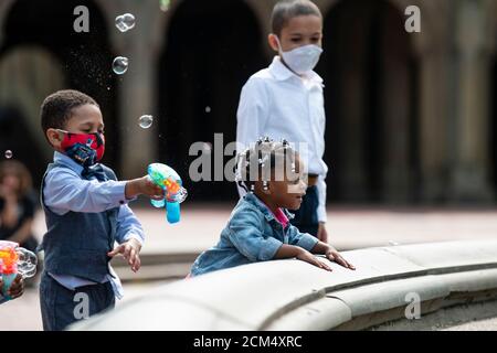 Manhattan, New York, USA. 16th Sep, 2020. Young children chase bubbles as they play at The Bethesda Fountain in Central Park while wearing PPE masks after taking part in an outdoor wedding in Manhattan, New York. Mandatory credit: Kostas Lymperopoulos/CSM/Alamy Live News Stock Photo