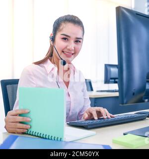 Young customer service women agent with headsets and computer working at office. Professional operator concept. Stock Photo