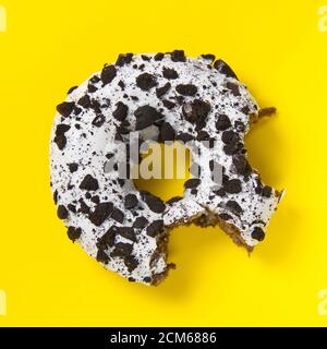 chocolate donut with white glaze isolated on yellow background, close up. Stock Photo