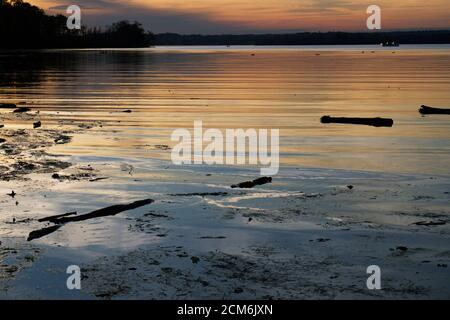 Vivid sunset over the Belmont Bay of water, with coast in silhouette Stock Photo