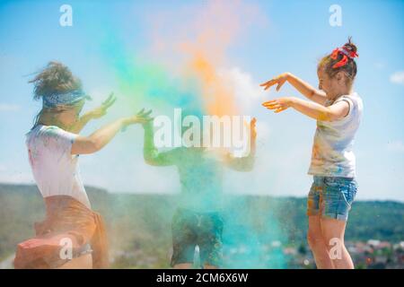 Group of kids enjoying playing with colored powder and color dust splash. Stock Photo