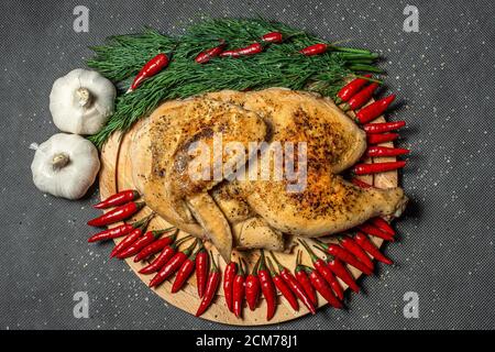 fried chicken, roasted half chicken, served vegetable, sprinkled with spices, garlic and red hot mini pepper Stock Photo