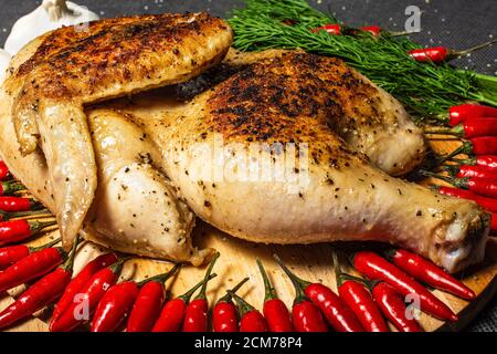 fried chicken, roasted half chicken, served vegetable, sprinkled with spices, garlic and red hot mini pepper Stock Photo