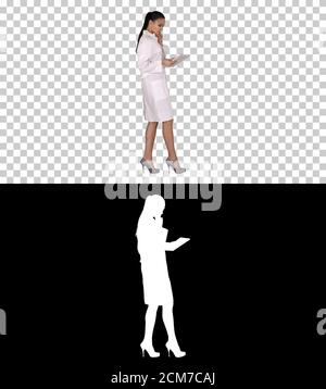 Woman doctor using tablet pc and walking, Alpha Channel Stock Photo