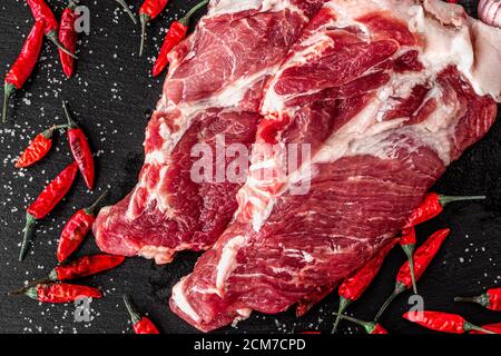 two pieces of fresh marbled beef on a dark background, with spices for cooking steak, horizontal Stock Photo