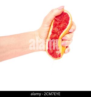 Hand squeezing a grapefruit to a large amount of juice Stock Photo