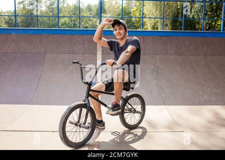 Rider resting on bmx, sitting on cycle in skate park Stock Photo