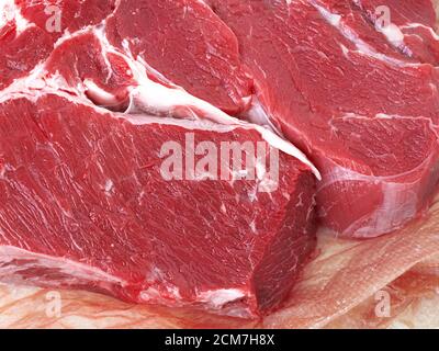 Fresh piece Raw beef meat on wrapping paper. Close up of details raw beef meat. Top view Stock Photo