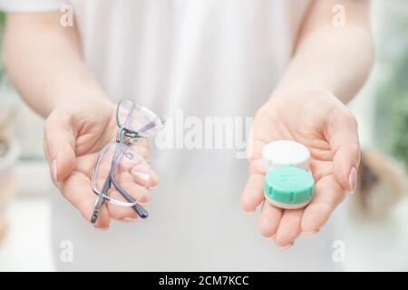 Young woman hands holding glass jar with coins inside, on white background Stock Photo