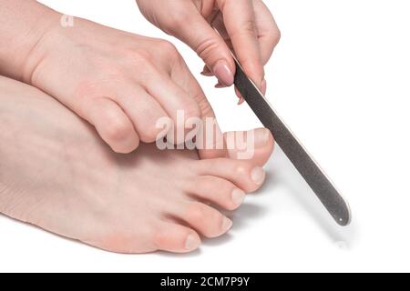 woman with a nail file. cares for toenails. close-up. isolated on white background Stock Photo