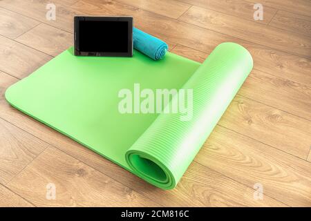 online yoga, doing yoga at home, on the wooden floor, Equipment for yoga. Concept healthy lifestyle, sport and diet. Stock Photo