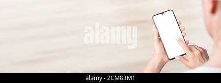 Mockup image of woman's hands holding modern cell mobile phone with blank screen, indoor, banner Stock Photo