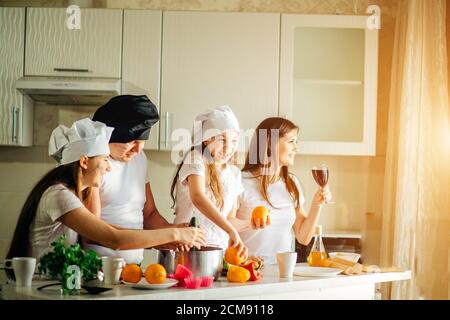 family making fresh organic juice in kitchen together. Stock Photo