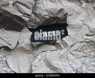a word Concept under a torn foil paper, a business marketing concept Stock Photo